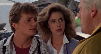 Movie still from “Back to the Future” (1985), directed by Robert Zemeckis – A young woman and a young man standing next to each other in front of an umbrella; Close Up shot, Over the shoulder angle
