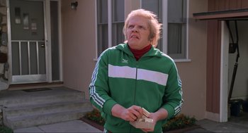 Movie still from “Back to the Future Part II” (1989), directed by Robert Zemeckis – A man in a green and white jacket holding a camera; Medium shot, Low angle