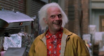 Movie still from “Back to the Future Part II” (1989), directed by Robert Zemeckis – A man with a white wig is smiling for the camera; Close Up shot, Over the shoulder angle
