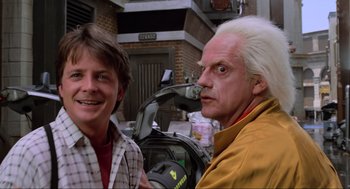 Movie still from “Back to the Future Part II” (1989), directed by Robert Zemeckis – Two men standing next to each other in front of a building; Medium shot, Low angle
