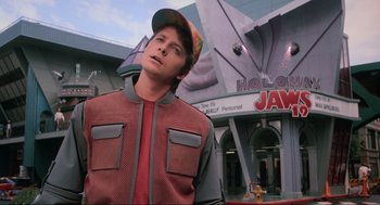 Movie still from “Back to the Future Part II” (1989), directed by Robert Zemeckis – A man in a red jacket and a brown hat; Medium shot, Over the shoulder angle