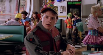 Movie still from “Back to the Future Part II” (1989), directed by Robert Zemeckis – A young man wearing a red and yellow jacket and a red hat; Close Up shot, Over the shoulder angle