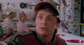 Movie still from “Back to the Future Part II” (1989), directed by Robert Zemeckis – A young man wearing a hat and looking surprised; Close Up shot, Over the shoulder angle
