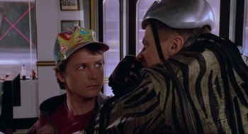 Movie still from “Back to the Future Part II” (1989), directed by Robert Zemeckis – A man with a hat on his head and another man with a helmet on his head; Close Up shot, Over the shoulder angle
