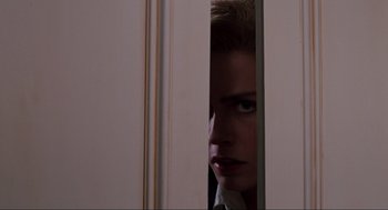 Movie still from “Back to the Future Part II” (1989), directed by Robert Zemeckis – A woman looking through a door frame at the camera; Extreme Close Up shot, Low angle