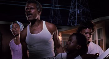 Movie still from “Back to the Future Part II” (1989), directed by Robert Zemeckis – A man and a woman standing next to each other in front of power lines at night; Medium shot, Low angle