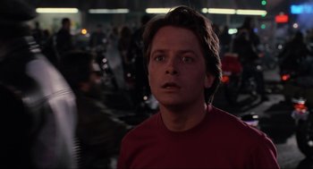 Movie still from “Back to the Future Part II” (1989), directed by Robert Zemeckis – A man in a red shirt is looking at the camera; Close Up shot, Low angle