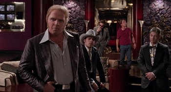 Movie still from “Back to the Future Part II” (1989), directed by Robert Zemeckis – A group of men in suits and hats standing in a room; Medium shot, Over the shoulder angle
