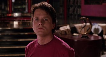 Movie still from “Back to the Future Part II” (1989), directed by Robert Zemeckis – A man in a red shirt is looking at the camera; Close Up shot, Over the shoulder angle