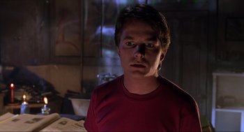Movie still from “Back to the Future Part II” (1989), directed by Robert Zemeckis – A man in a red t - shirt stares into the camera; Close Up shot, Low angle