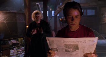 Movie still from “Back to the Future Part II” (1989), directed by Robert Zemeckis – A man and a woman are reading a newspaper together; Close Up shot, Over the shoulder angle