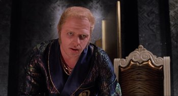 Movie still from “Back to the Future Part II” (1989), directed by Robert Zemeckis – A man with blonde hair wearing a blue robe; Close Up shot, Over the shoulder angle