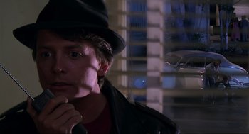 Movie still from “Back to the Future Part II” (1989), directed by Robert Zemeckis – A young man wearing a black hat and a leather jacket; Close Up shot, Over the shoulder angle
