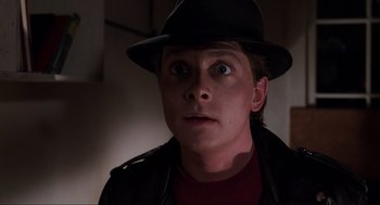 Movie still from “Back to the Future Part II” (1989), directed by Robert Zemeckis – A man wearing a black hat and a red shirt; Close Up shot, Over the shoulder angle