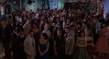 Movie still from “Back to the Future Part II” (1989), directed by Robert Zemeckis – A large group of people dressed up for a party; Wide shot, High angle