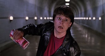 Movie still from “Back to the Future Part II” (1989), directed by Robert Zemeckis – A person in a tunnel holding a book; Medium shot, Low angle