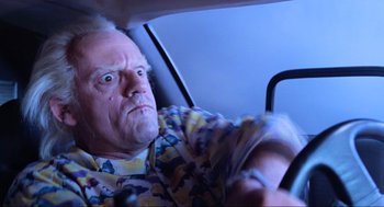 Movie still from “Back to the Future Part II” (1989), directed by Robert Zemeckis – An older man driving a car in the dark; Close Up shot, Over the shoulder angle