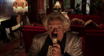 Movie still from “Back to the Future Part III” (1990), directed by Robert Zemeckis – An older man is drinking from a cup; Medium shot, Low angle