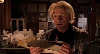 Movie still from “Back to the Future Part III” (1990), directed by Robert Zemeckis – A man holding a piece of wood in his hands; Close Up shot, Low angle