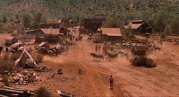 Movie still from “Back to the Future Part III” (1990), directed by Robert Zemeckis – A man standing on the side of a dirt road; Extreme Wide shot, High angle