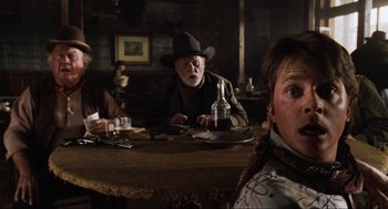 Movie still from “Back to the Future Part III” (1990), directed by Robert Zemeckis – A group of people sitting at a table with drinks; Close Up shot, Over the shoulder angle