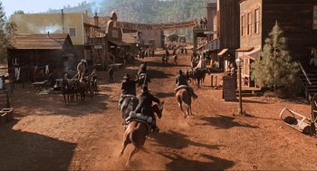 Movie still from “Back to the Future Part III” (1990), directed by Robert Zemeckis – A group of people riding horses down a dirt road; Extreme Wide shot, High angle