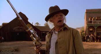 Movie still from “Back to the Future Part III” (1990), directed by Robert Zemeckis – A man in a hat holding a telescope; Medium shot, Low angle