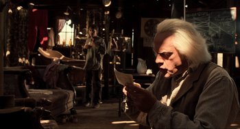 Movie still from “Back to the Future Part III” (1990), directed by Robert Zemeckis – An older man reading a letter in a living room; Medium shot, Over the shoulder angle