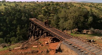 Movie still from “Back to the Future Part III” (1990), directed by Robert Zemeckis – Two people on a bridge over a river; Extreme Wide shot, High angle