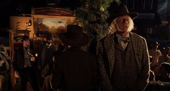 Movie still from “Back to the Future Part III” (1990), directed by Robert Zemeckis – A man in a hat and a suit standing next to a tree; Medium shot, Over the shoulder angle