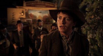 Movie still from “Back to the Future Part III” (1990), directed by Robert Zemeckis – A young man in a cowboy hat is looking at the camera; Close Up shot, Over the shoulder angle