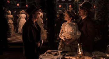 Movie still from “Back to the Future Part III” (1990), directed by Robert Zemeckis – A group of people standing next to a table; Medium shot, Over the shoulder angle