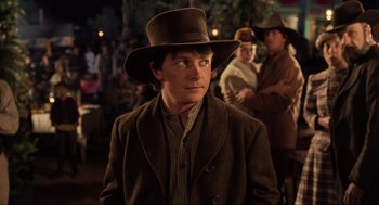 Movie still from “Back to the Future Part III” (1990), directed by Robert Zemeckis – A man wearing a brown hat and a brown jacket; Medium shot, Over the shoulder angle