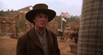 Movie still from “Back to the Future Part III” (1990), directed by Robert Zemeckis – A man wearing a brown hat and a brown jacket; Medium shot, Over the shoulder angle