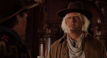 Movie still from “Back to the Future Part III” (1990), directed by Robert Zemeckis – A man in a cowboy hat and a brown jacket; Medium shot, Over the shoulder angle