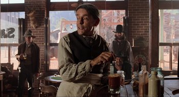 Movie still from “Back to the Future Part III” (1990), directed by Robert Zemeckis – An old man in an old western style restaurant; Medium shot, Over the shoulder angle