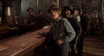 Movie still from “Back to the Future Part III” (1990), directed by Robert Zemeckis – A group of people standing around a bar; Medium shot, Low angle