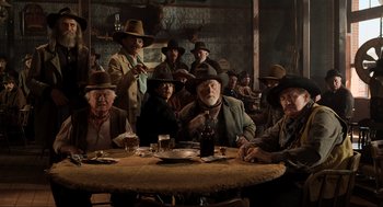 Movie still from “Back to the Future Part III” (1990), directed by Robert Zemeckis – A group of men sitting at a table with drinks; Wide shot, Low angle