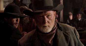 Movie still from “Back to the Future Part III” (1990), directed by Robert Zemeckis – An old man with a gray beard wearing a brown hat; Close Up shot, Low angle