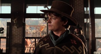 Movie still from “Back to the Future Part III” (1990), directed by Robert Zemeckis – A man wearing a cowboy hat in front of a window; Close Up shot, Over the shoulder angle