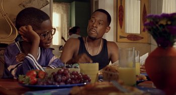 Movie still from “Bad Boys” (1995), directed by Michael Bay – A man sitting at a dinner table with a woman; Medium shot, Over the shoulder angle