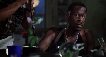 Movie still from “Bad Boys” (1995), directed by Michael Bay – A man sitting at a table with a phone in his hand; Close Up shot, Low angle