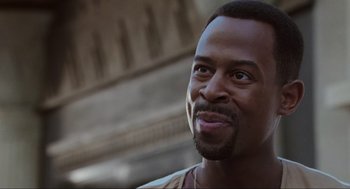 Movie still from “Bad Boys” (1995), directed by Michael Bay – A person smiling for the camera; Close Up shot, Over the shoulder angle