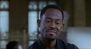 Movie still from “Bad Boys” (1995), directed by Michael Bay – A person wearing a black shirt; Close Up shot, Over the shoulder angle