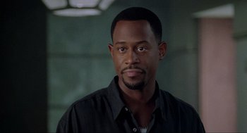 Movie still from “Bad Boys” (1995), directed by Michael Bay – A person wearing a black shirt; Close Up shot, Over the shoulder angle