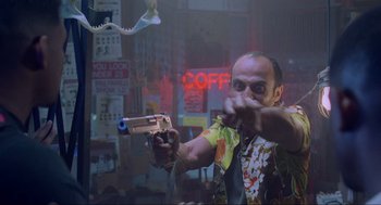 Movie still from “Bad Boys” (1995), directed by Michael Bay – A man holding a gun in a room with neon lights; Medium shot, Low angle