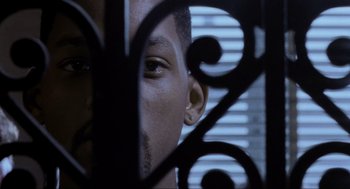 Movie still from “Bad Boys” (1995), directed by Michael Bay – A man's face through a fence; Extreme Close Up shot, Low angle