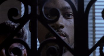 Movie still from “Bad Boys” (1995), directed by Michael Bay – A person looking through a fence; Close Up shot, Over the shoulder angle