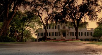 Movie still from “Bad Boys” (1995), directed by Michael Bay – A large white house sitting in the middle of a street; Extreme Wide shot, Low angle