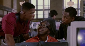 Movie still from “Bad Boys” (1995), directed by Michael Bay – A group of men standing next to each other in front of a computer; Medium shot, Over the shoulder angle